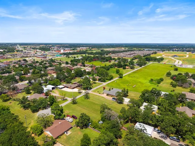 an aerial view of residential houses with outdoor space and trees