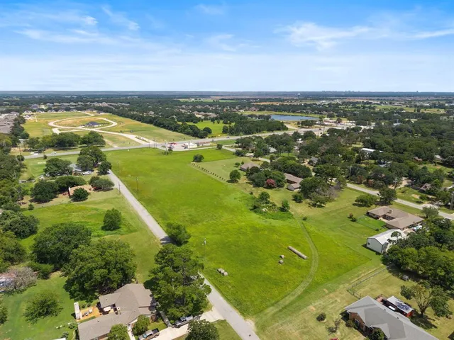 an aerial view of residential houses with outdoor space and trees