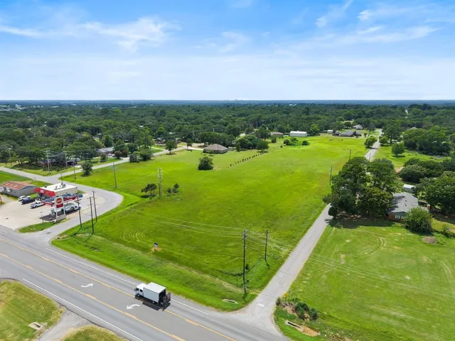 an aerial view of a golf course with huge green field and large trees