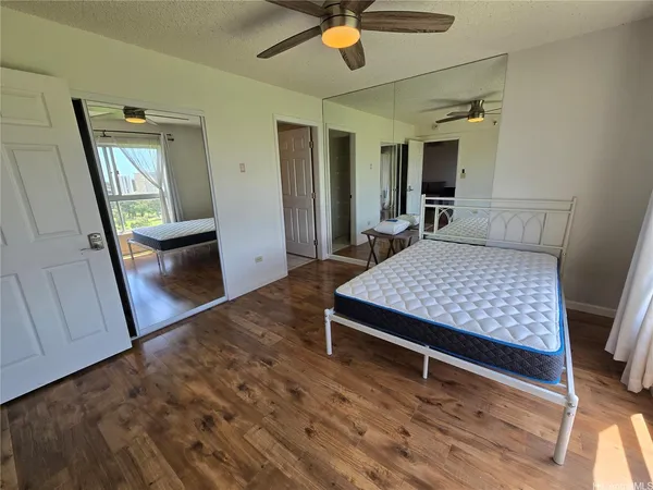 a bedroom with a bed and a mirror on the dresser