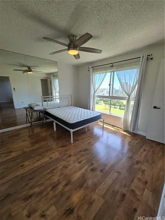 an empty room with windows and ceiling fan