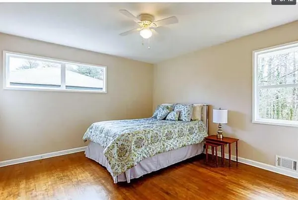 a bedroom with a bed chandelier and a window