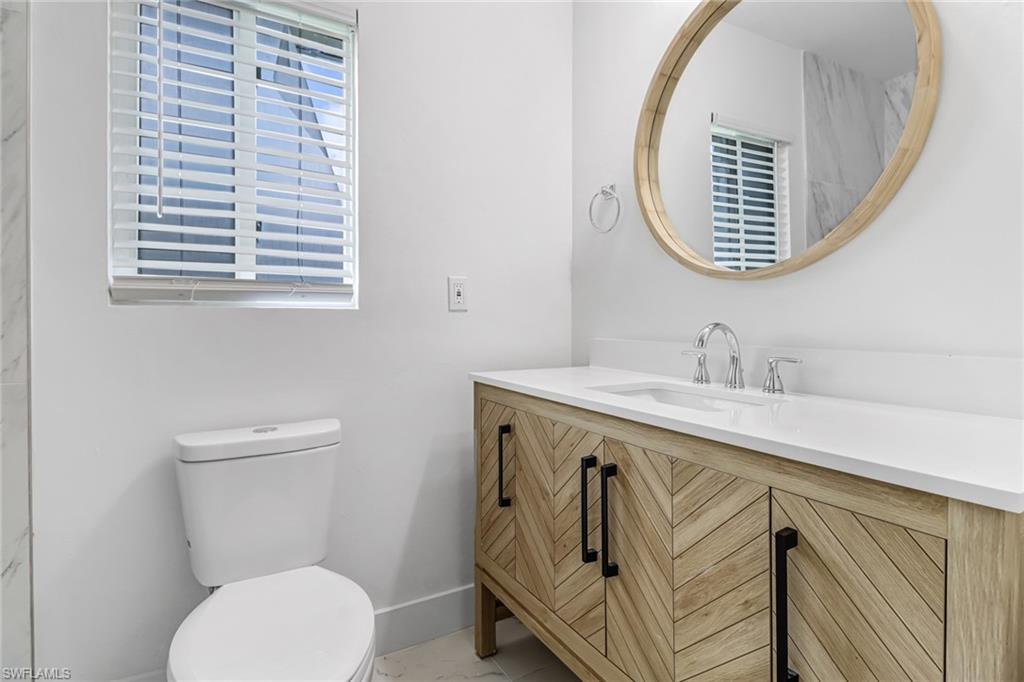 981 11th Street Southwest Naples, FL 34117 - Photo 14 of 24 Bathroom with vanity, toilet, and a healthy amount of sunlight