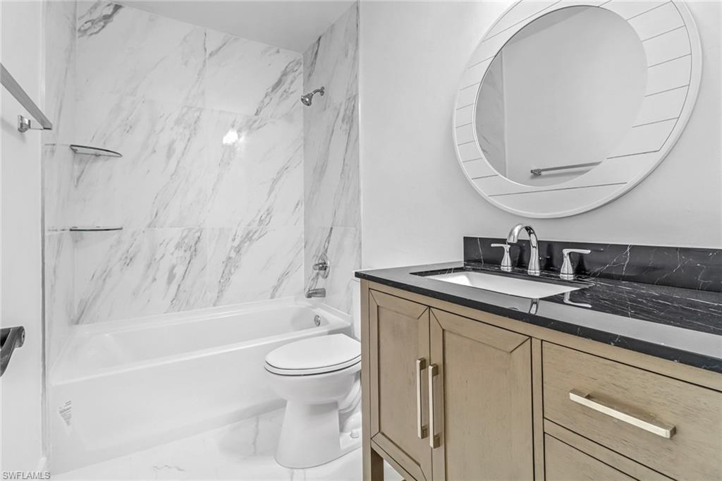 981 11th Street Southwest Naples, FL 34117 - Photo 15 of 24 Full bathroom with tiled shower / bath, vanity, and toilet