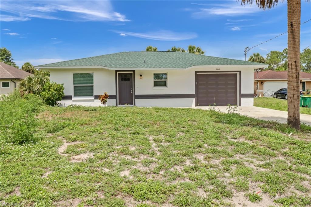 981 11th Street Southwest Naples, FL 34117 - Photo 2 of 24 Ranch-style house featuring a front lawn and a garage