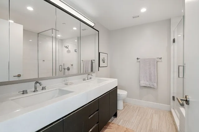 a bathroom with a sink a toilet a shower and a mirror