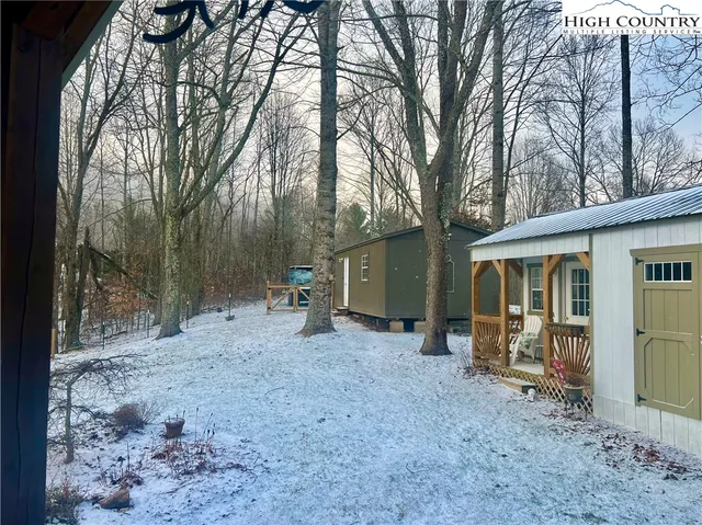 a view of a house with a backyard and trees