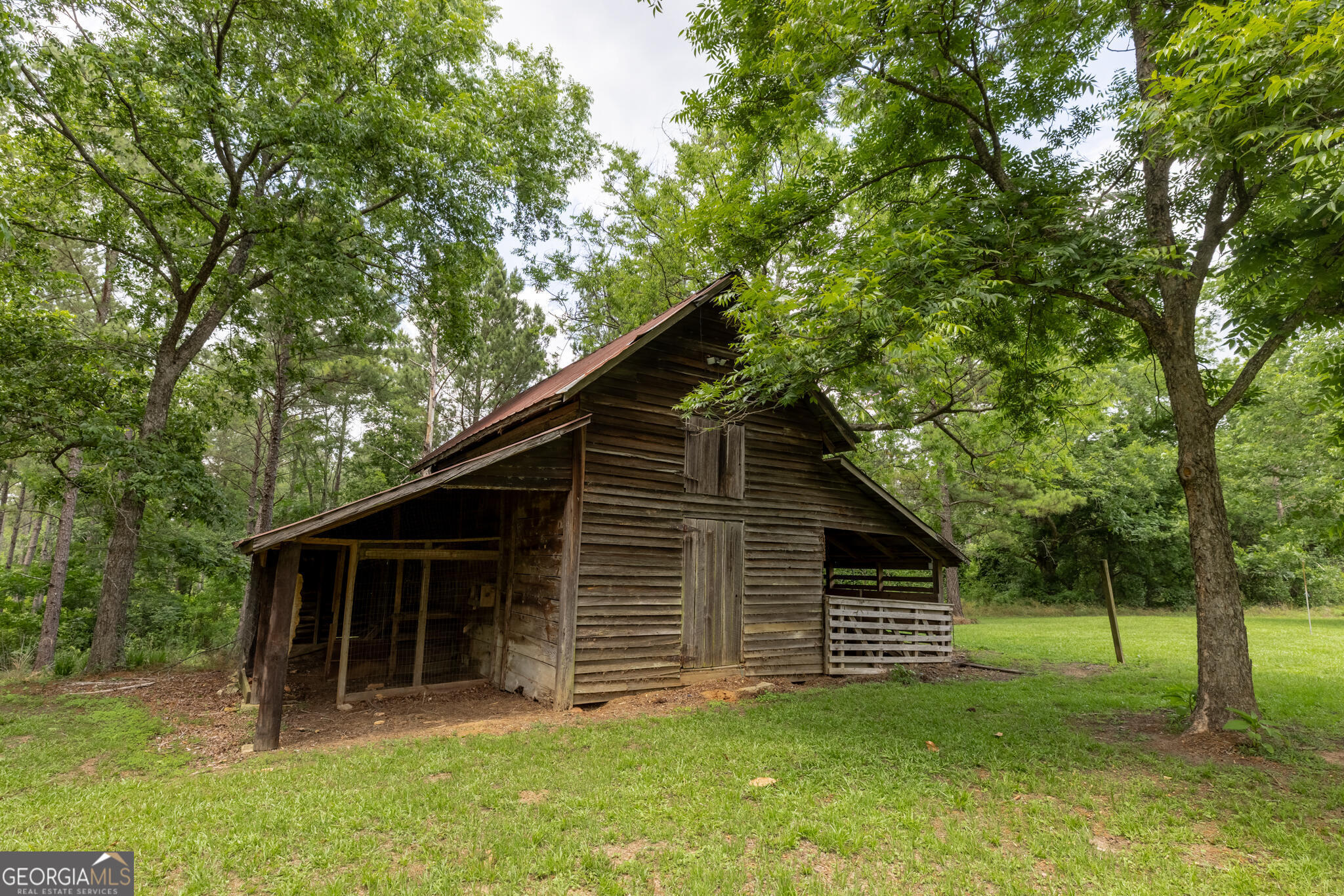 1859 Upper River Road Americus, GA 31709 - Photo 5 of 47 a backyard of a house with plants and large tree