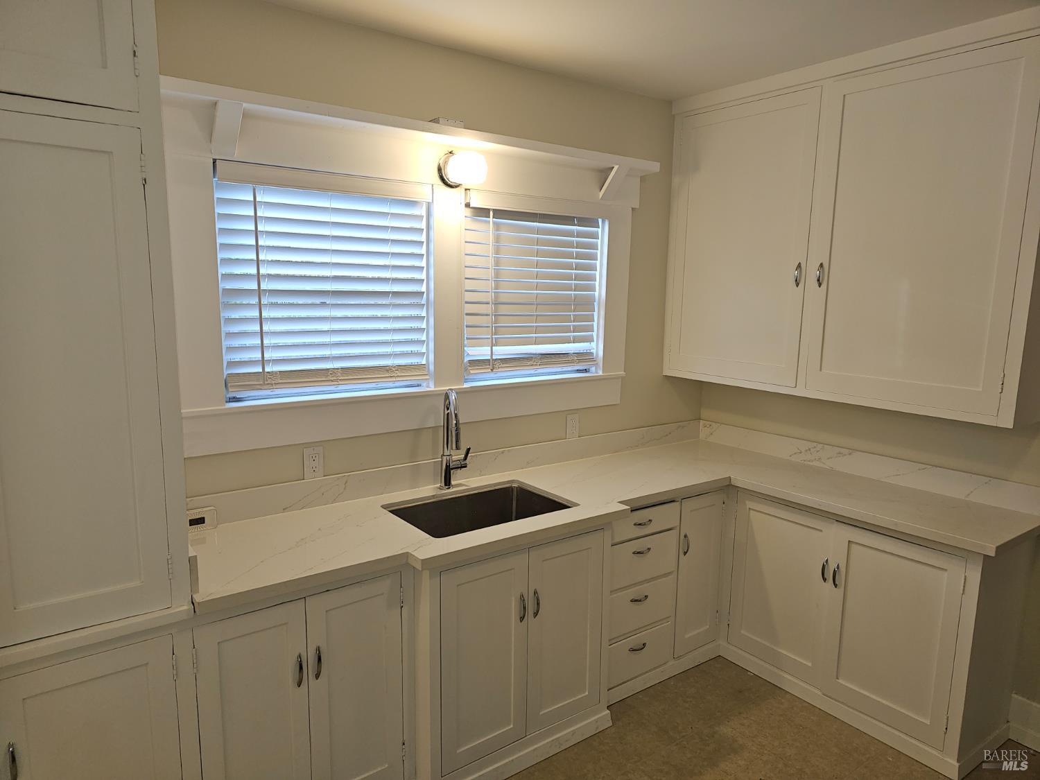 412 Lincoln Street Santa Rosa, CA 95401 - Photo 14 of 35 a kitchen with white cabinets and a window