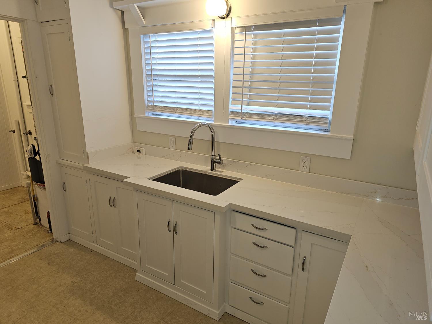 412 Lincoln Street Santa Rosa, CA 95401 - Photo 15 of 35 a kitchen with white cabinets and a sink