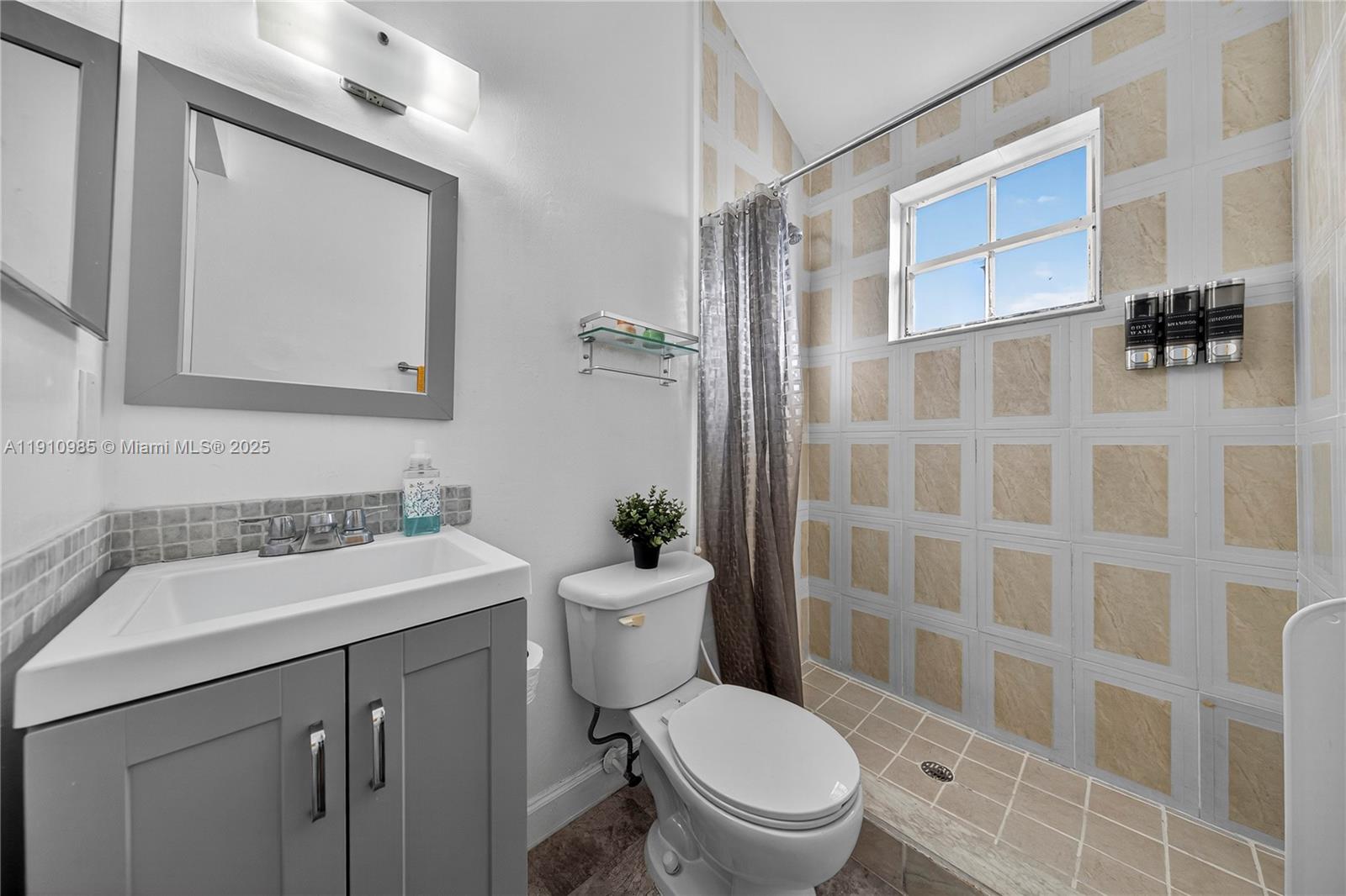 12045 Southwest 18th Street, Unit 142 Miami, FL 33175 - Photo 14 of 18 a bathroom with a sink a toilet a shower and a mirror