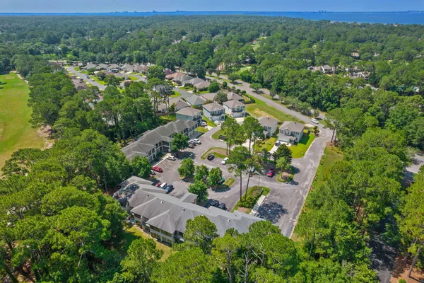 an aerial view of residential houses with outdoor space and trees