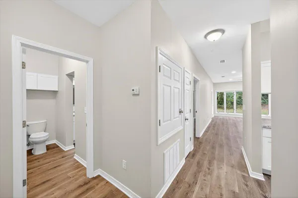 a view of a room with wooden floor and a toilet