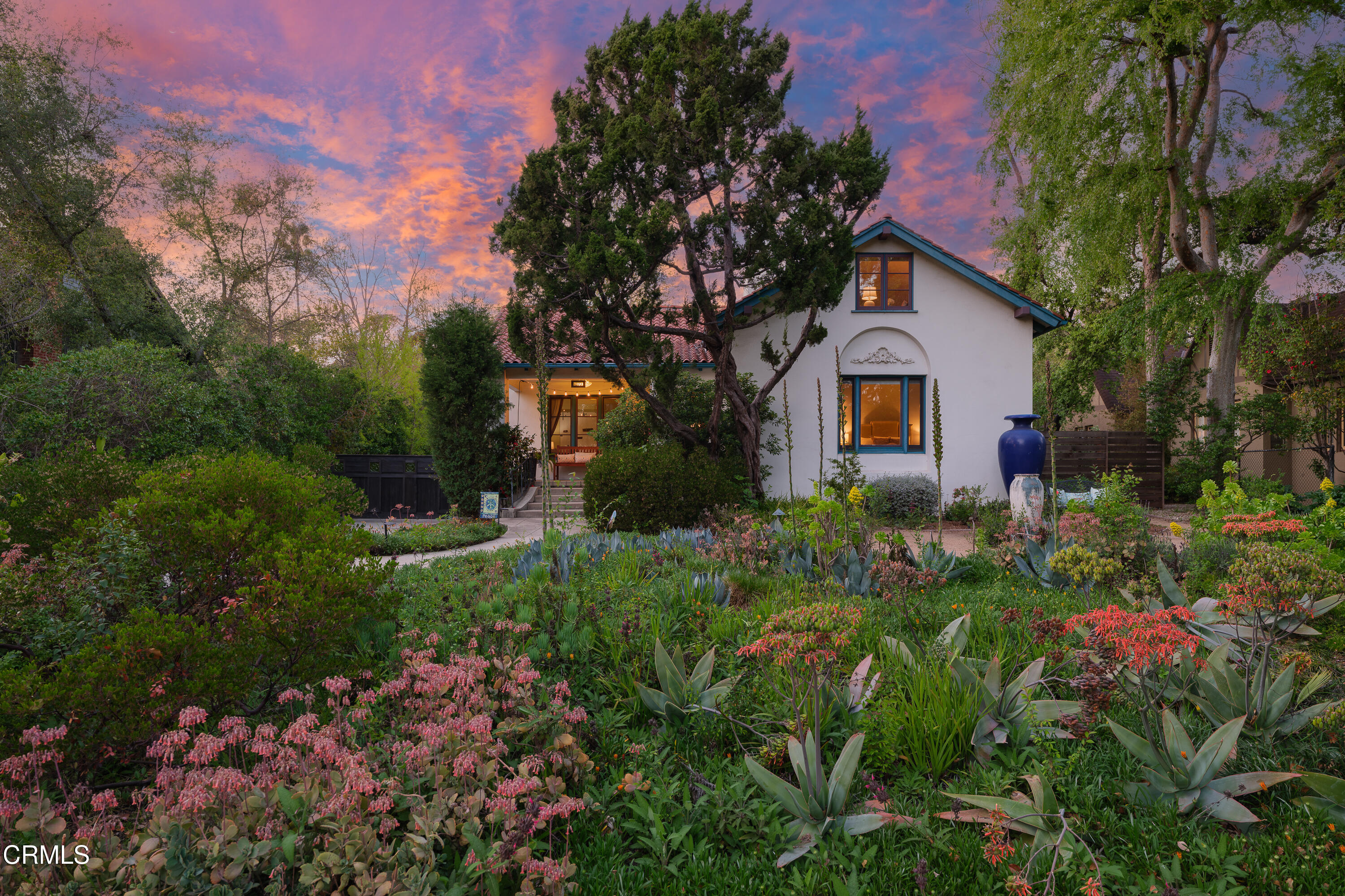 a front view of a house with a yard and tree