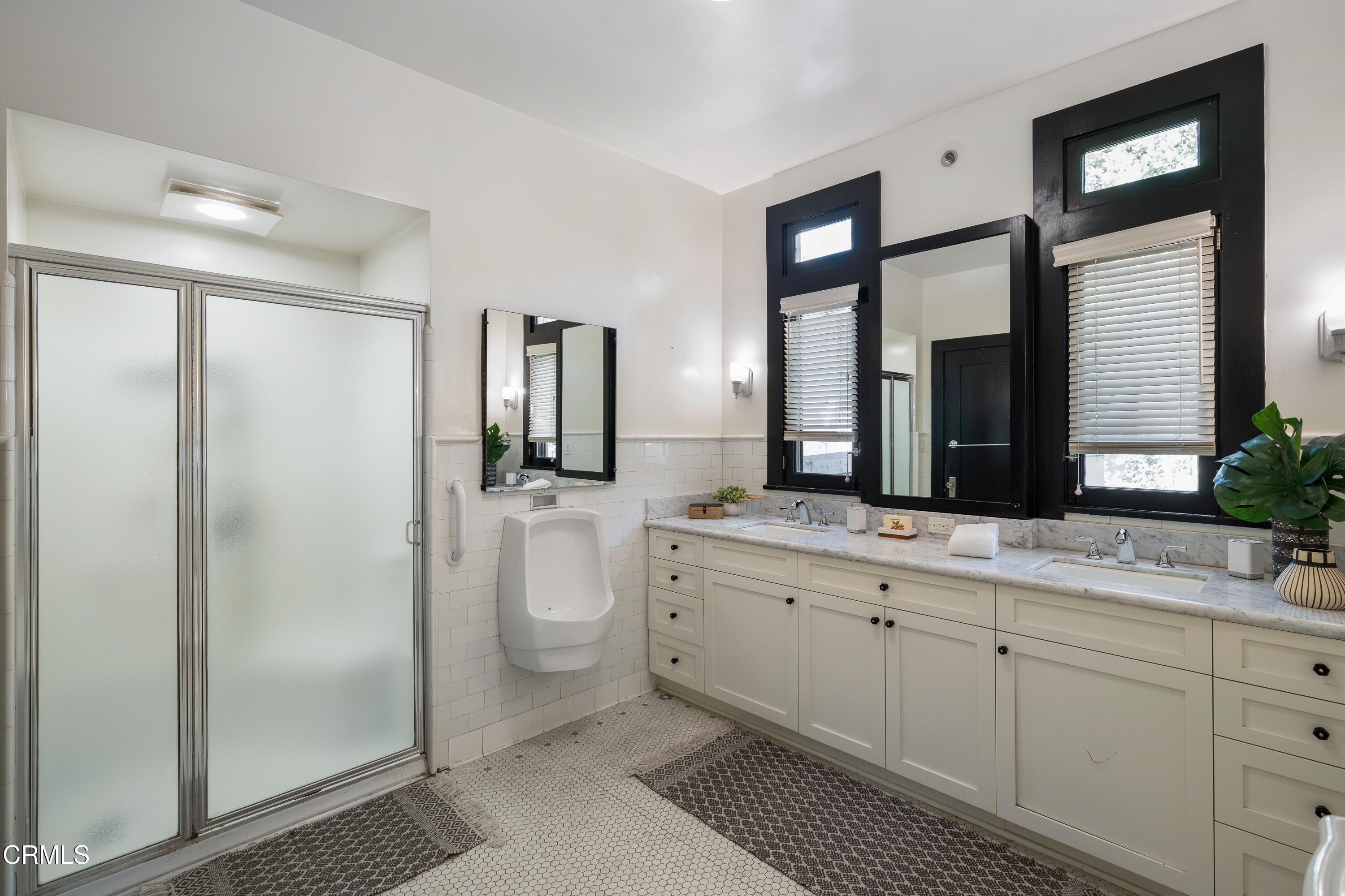 1073 Atchison Street Pasadena, CA 91104 - Photo 30 of 66 a spacious bathroom with a double vanity sink a large mirror a toilet and a shower