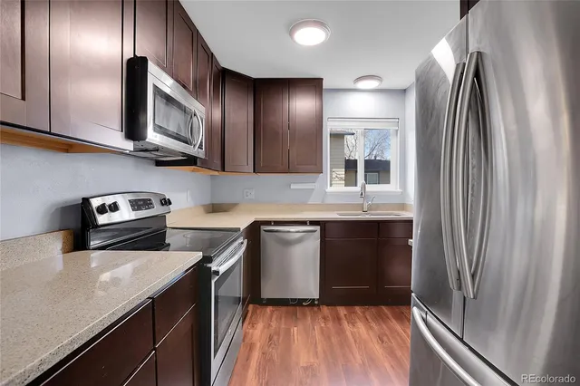 a kitchen with stainless steel appliances granite countertop a refrigerator sink and stove
