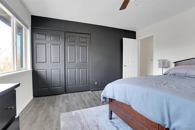 a bedroom with a bed and large windows