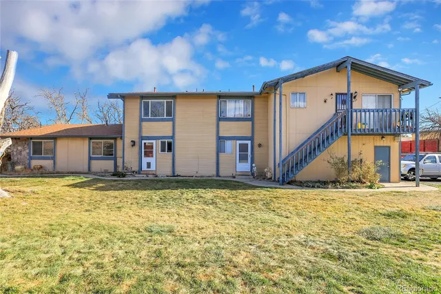 a view of a house with backyard and sitting area