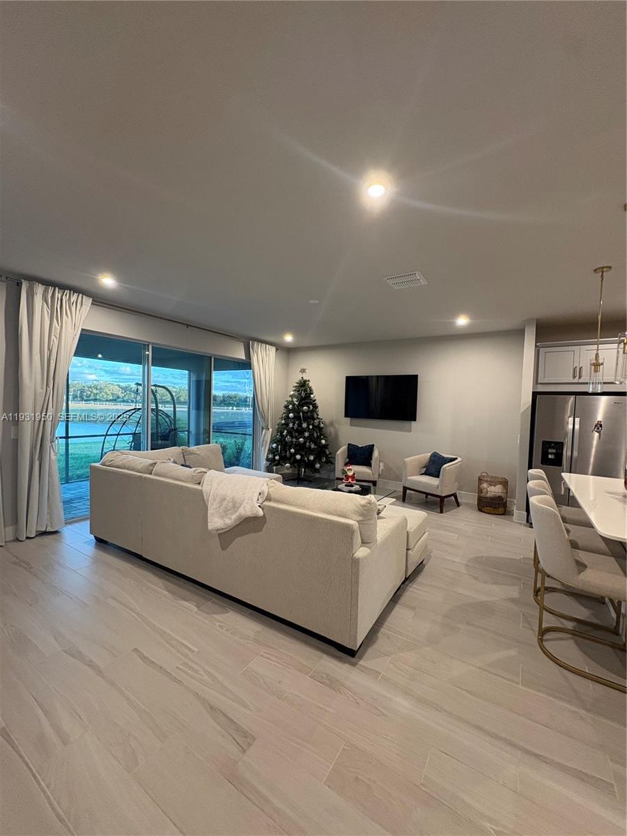 5020 124th Avenue East Parrish, FL 34219 - Photo 14 of 25 a living room with furniture a flat screen tv and a large window