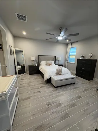 a spacious bedroom with a bed and a ceiling fan