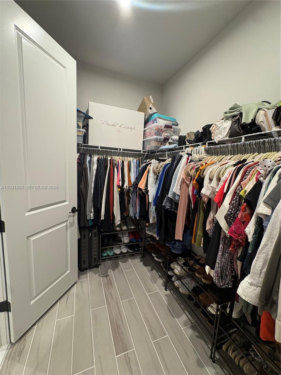 5020 124th Avenue East Parrish, FL 34219 - Photo 20 of 25 a view of walk in closet with clothes and shoes