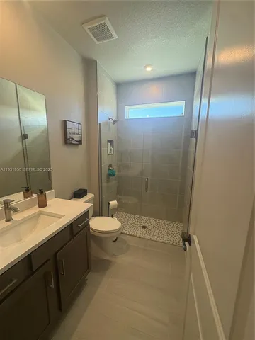 a bathroom with a double vanity sink toilet and shower