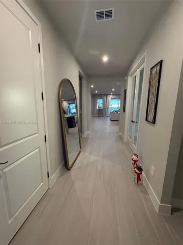 a view of a hallway with wooden floor and stairs