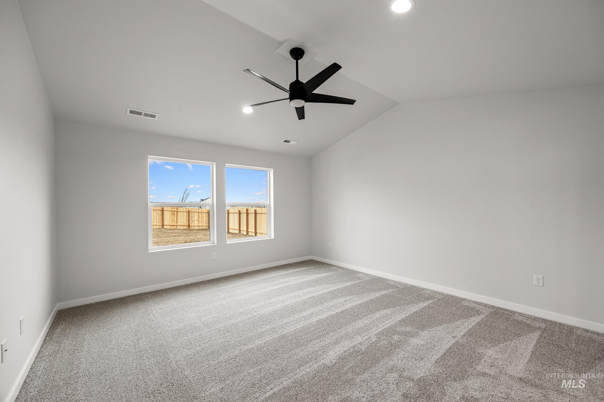 13654 Inman Court Caldwell, ID 83607 - Photo 19 of 25 Spare room featuring lofted ceiling, light colored carpet, and a ceiling fan