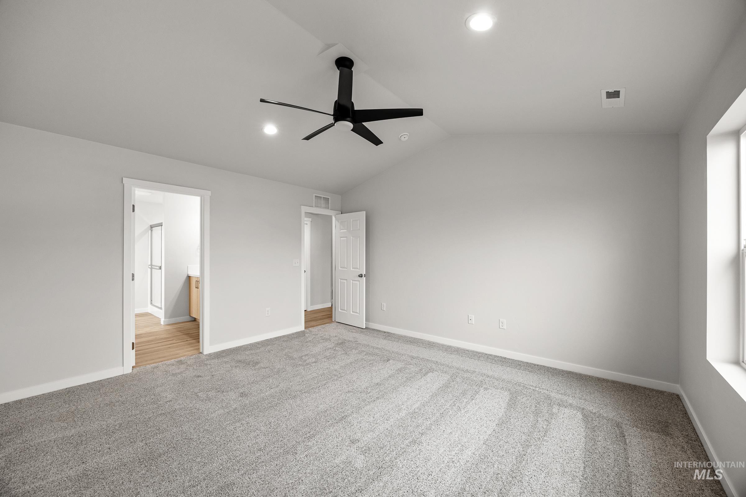 13654 Inman Court Caldwell, ID 83607 - Photo 20 of 25 Unfurnished bedroom with light colored carpet, lofted ceiling, a ceiling fan, ensuite bath, and recessed lighting