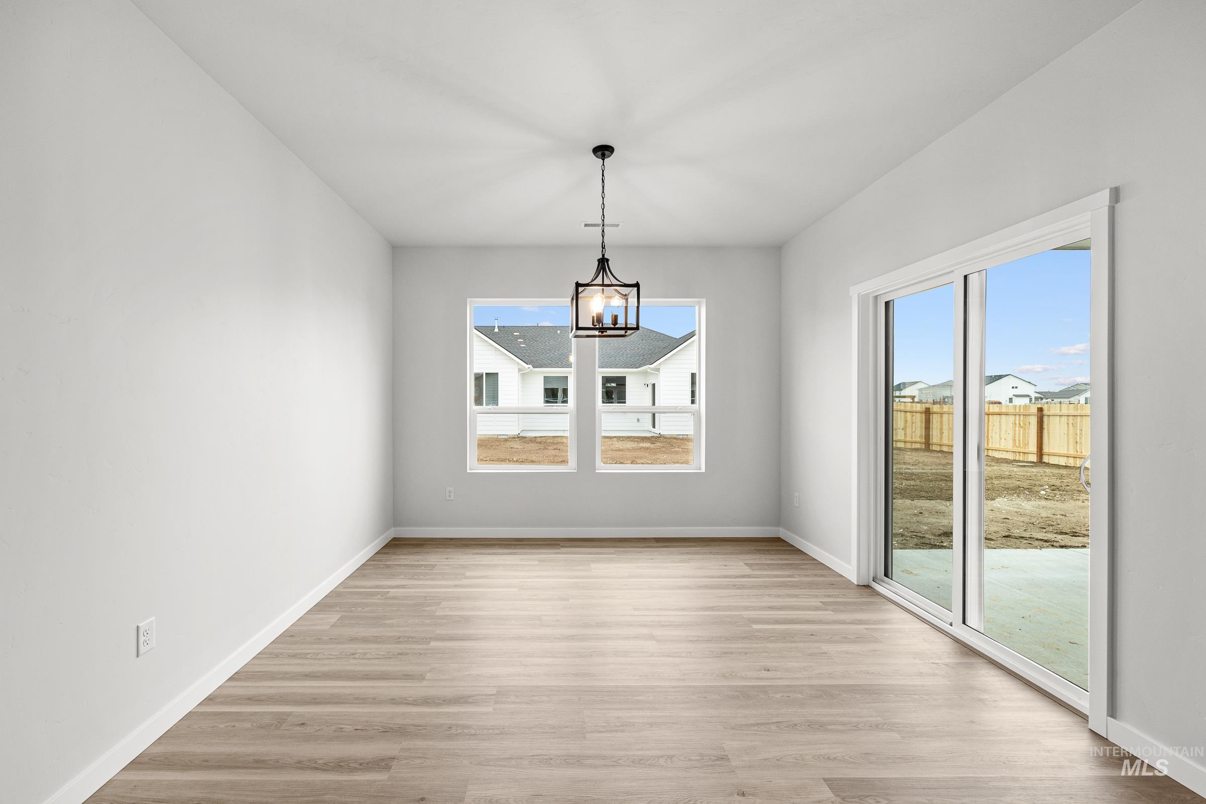 13654 Inman Court Caldwell, ID 83607 - Photo 6 of 25 Unfurnished dining area featuring light wood-style floors and suspended lighting