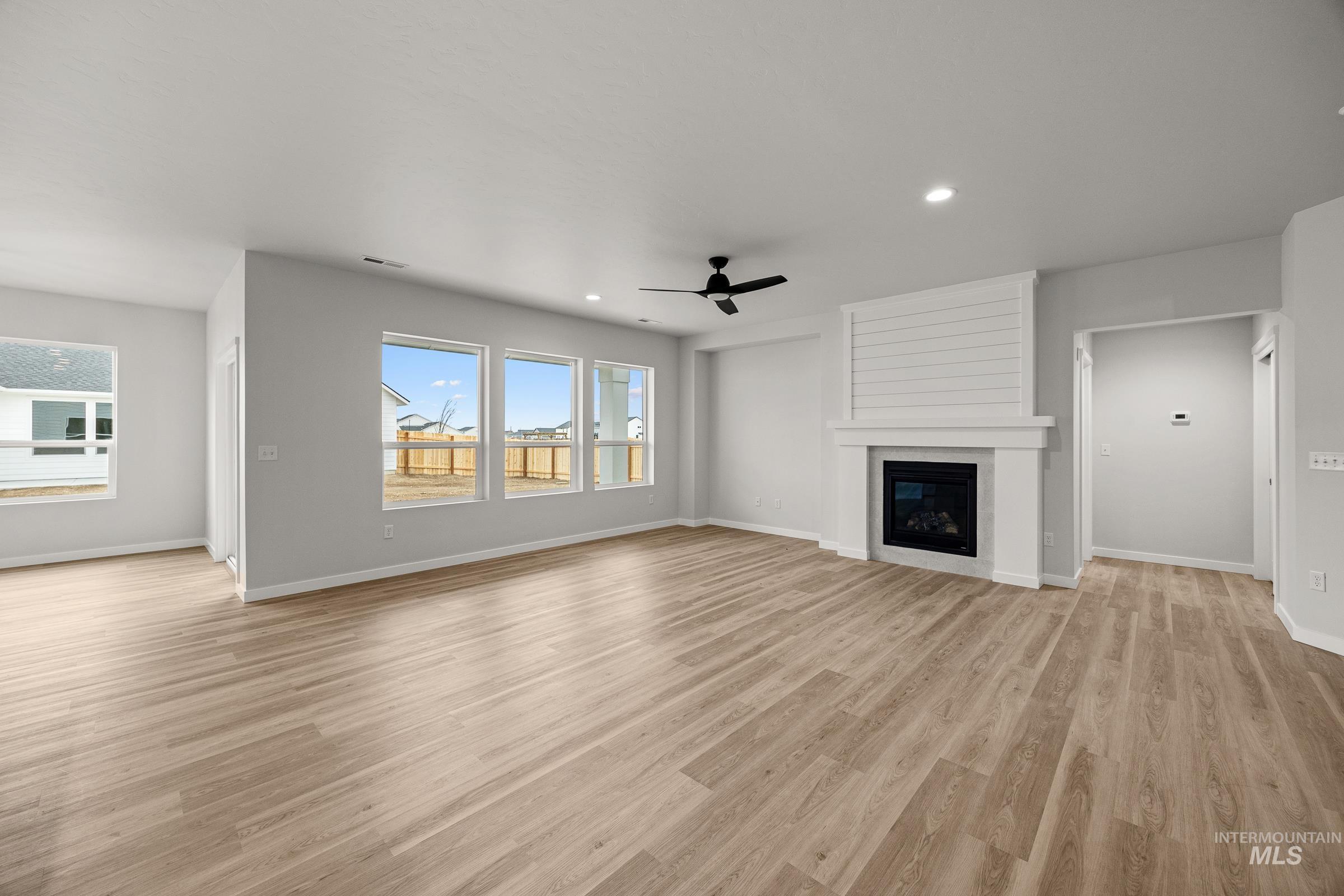 13654 Inman Court Caldwell, ID 83607 - Photo 8 of 25 Unfurnished living room with ceiling fan, light wood-type flooring, a fireplace, and recessed lighting