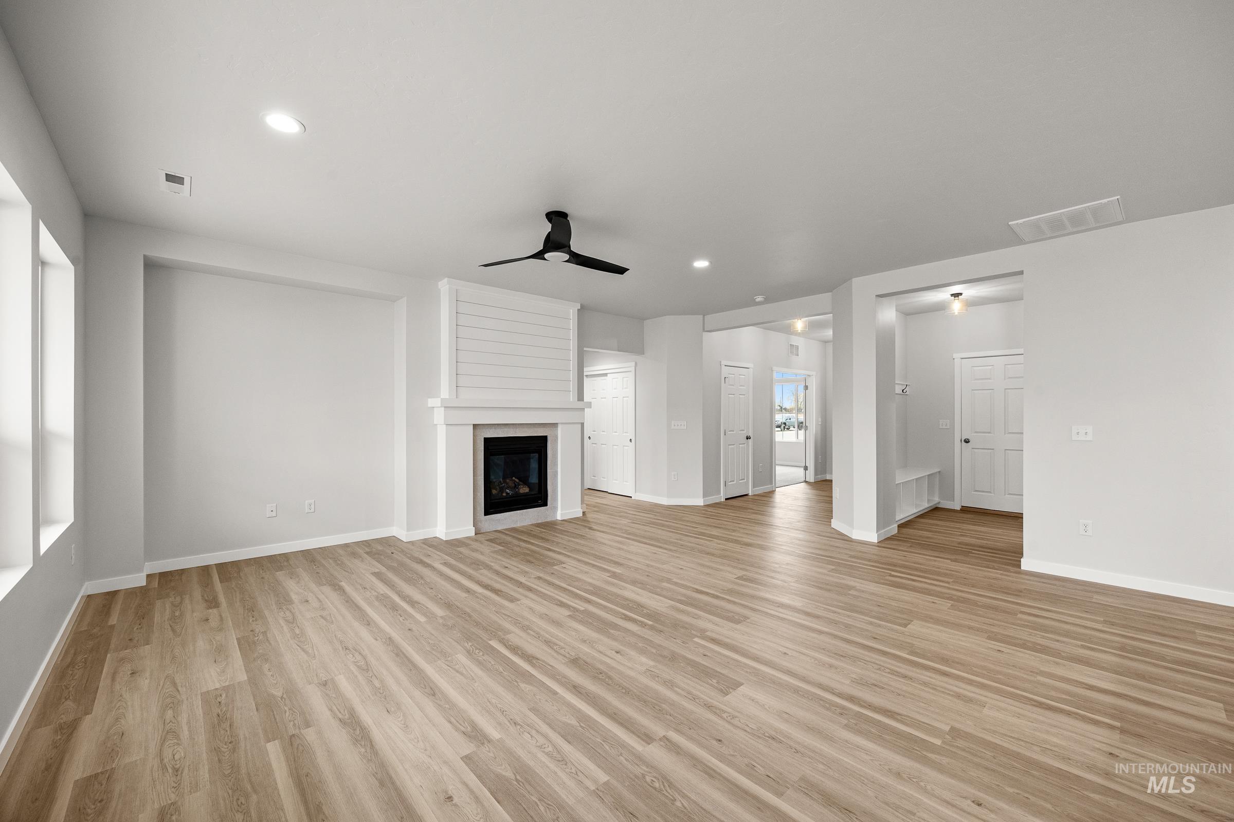 13654 Inman Court Caldwell, ID 83607 - Photo 9 of 25 Unfurnished living room with a ceiling fan, light wood-style flooring, a fireplace, and recessed lighting