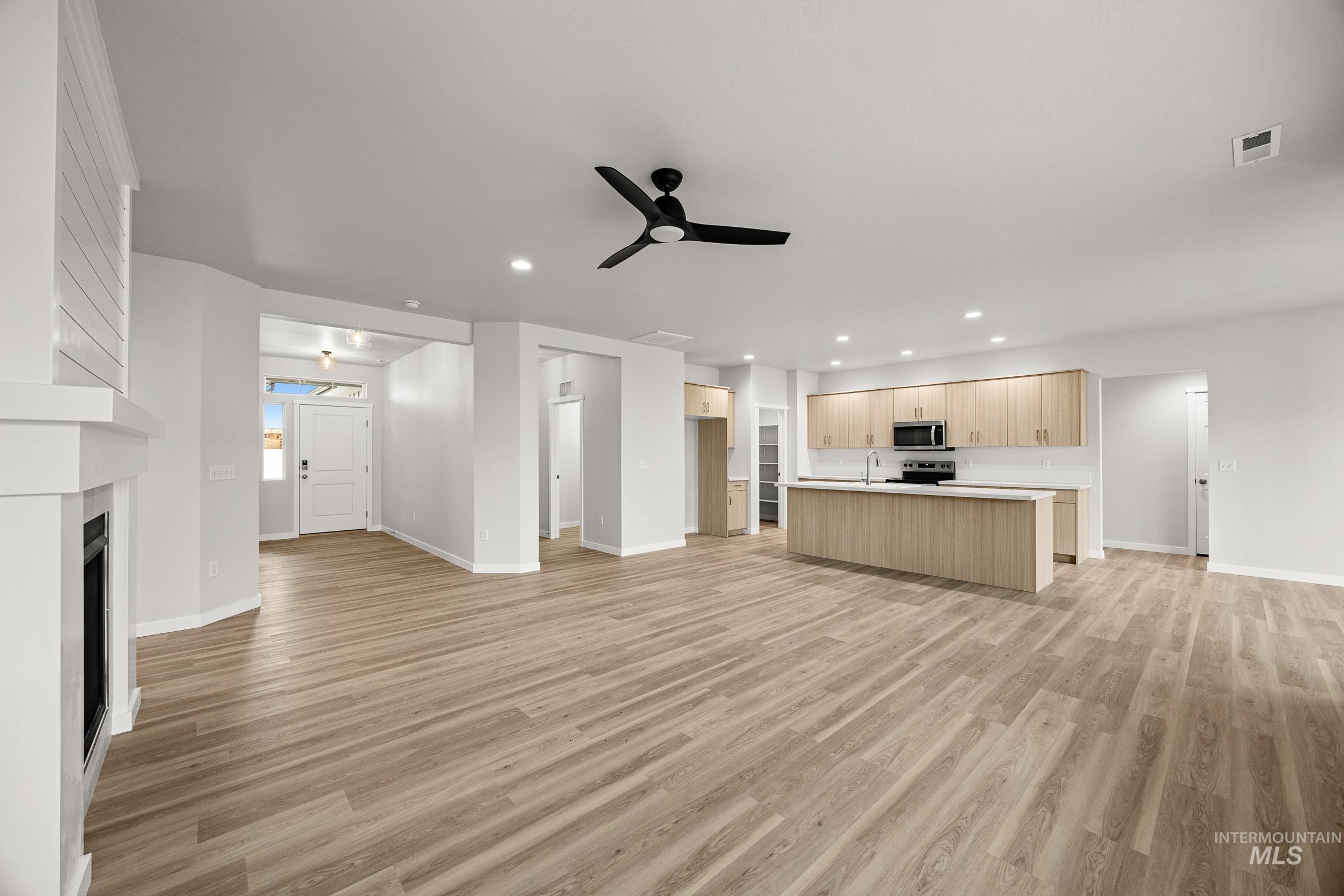 13654 Inman Court Caldwell, ID 83607 - Photo 10 of 25 Unfurnished living room featuring a ceiling fan, light wood-type flooring, recessed lighting, and a fireplace