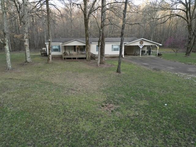 1405 Bruton Branch Road Savannah, TN 38372 - Photo 1 of 20 View of front of home featuring a detached carport, a front yard, a deck, and aphalt driveway