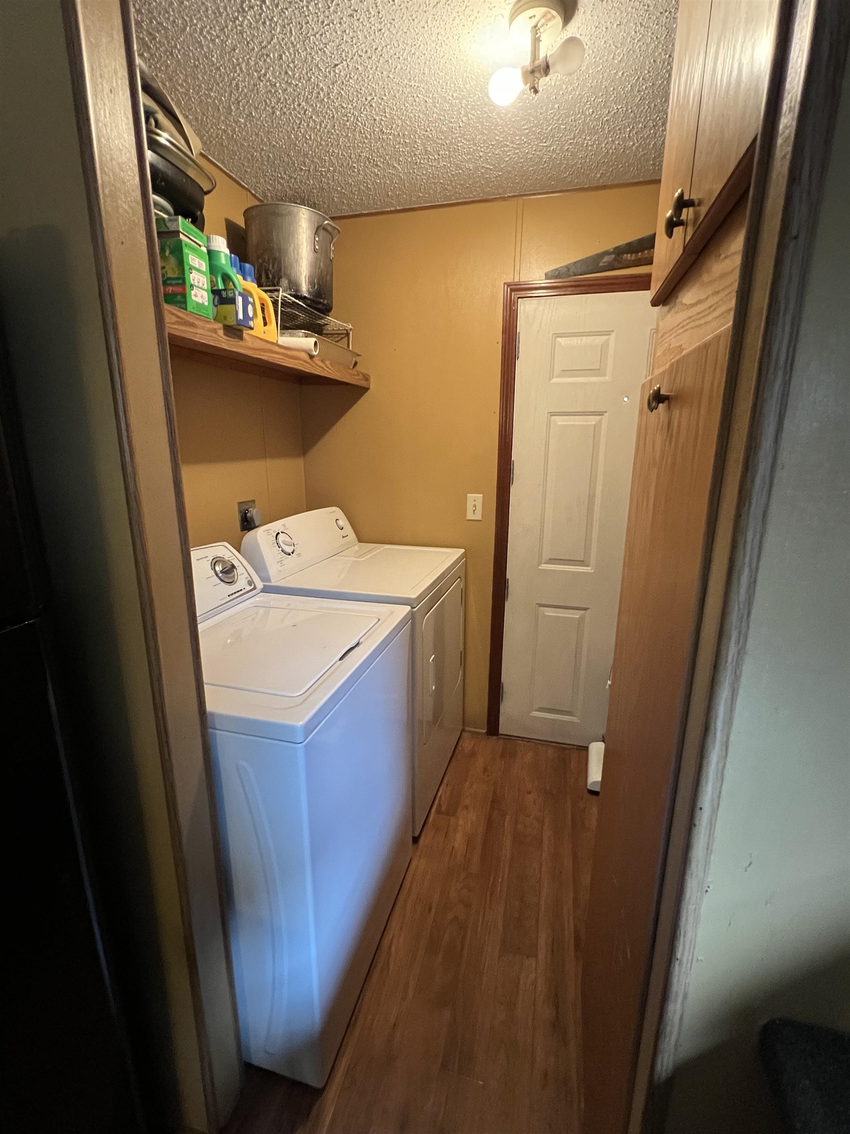 1405 Bruton Branch Road Savannah, TN 38372 - Photo 19 of 20 Laundry area featuring cabinet space, a textured ceiling, independent washer and dryer, and dark wood-style flooring