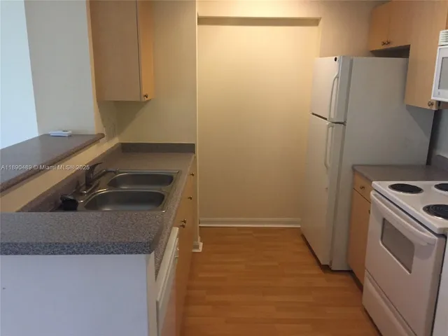 a kitchen with a sink and a refrigerator