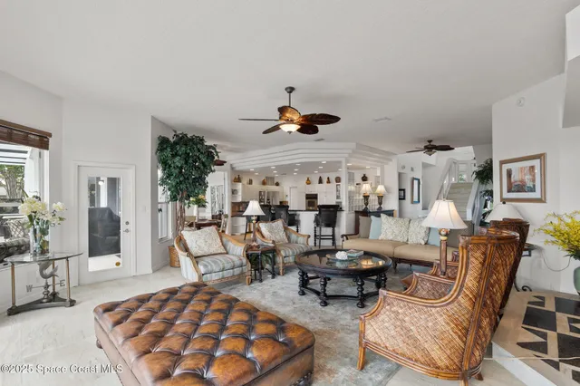 a living room with furniture floor to ceiling window and a rug