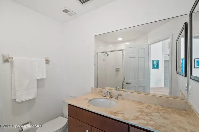 a front view of a house with a garden and lake