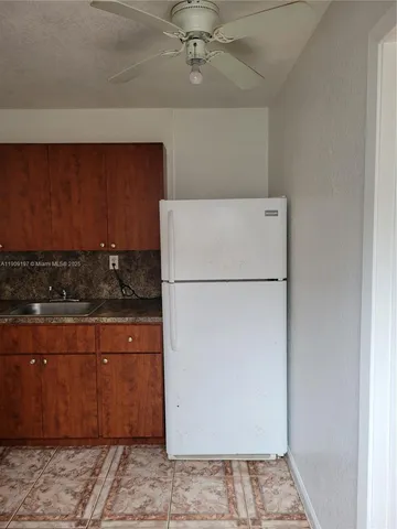 a kitchen with stainless steel appliances granite countertop a refrigerator a stove and a sink