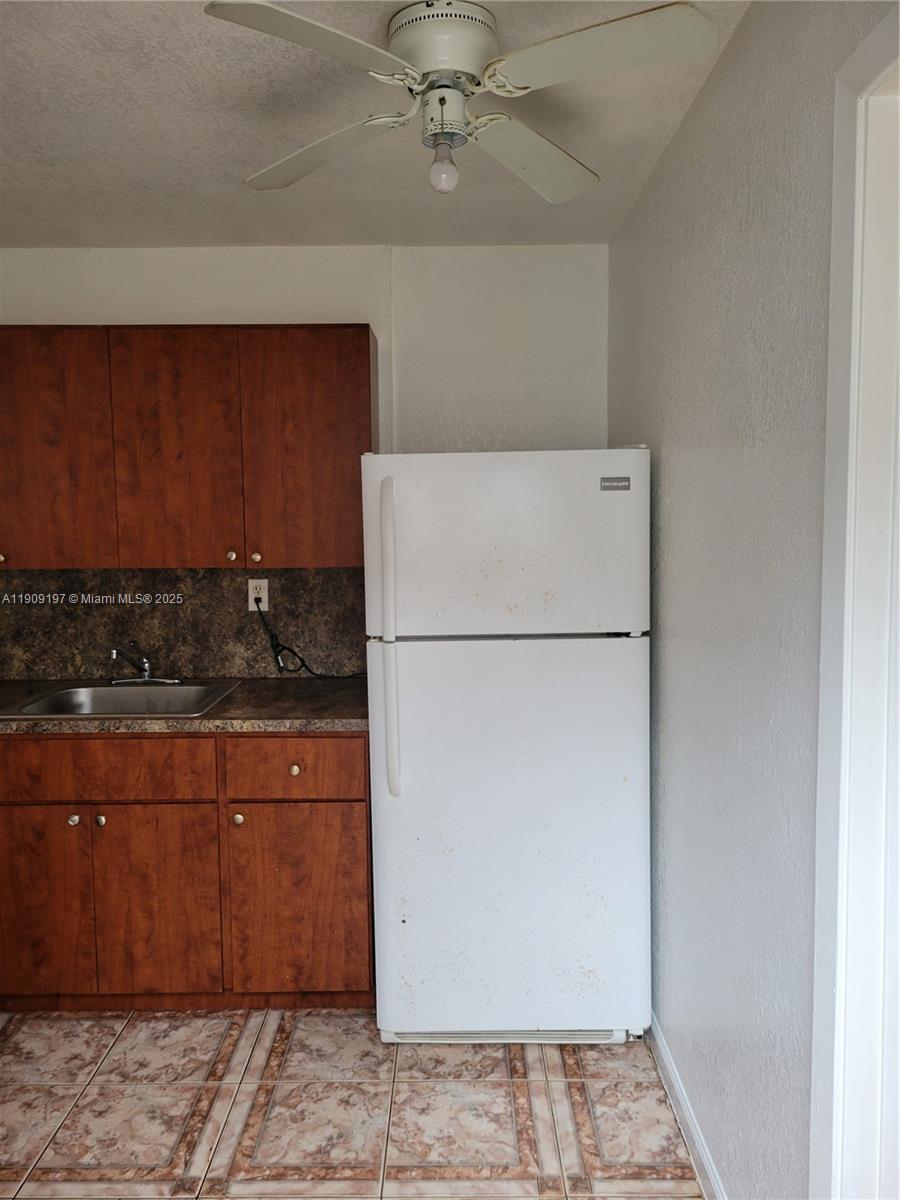 a kitchen with stainless steel appliances granite countertop a refrigerator a stove and a sink