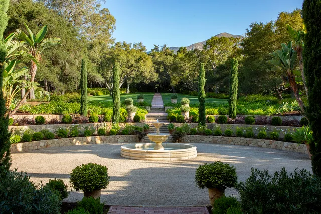 a view of house with a garden and mountains