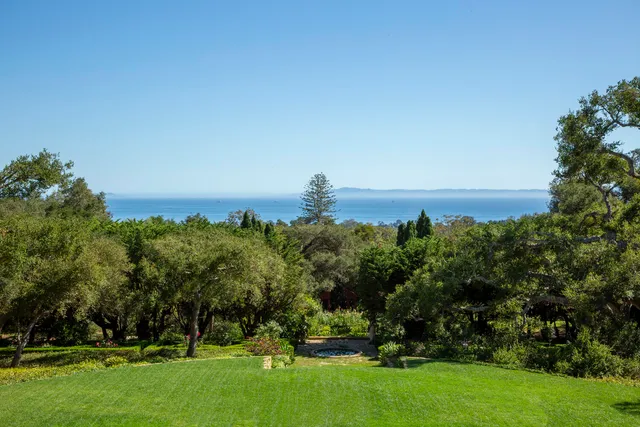 a living room with fireplace furniture and a large window