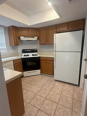 a kitchen with stainless steel appliances granite countertop a refrigerator sink and stove