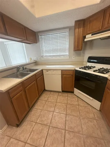 a kitchen with a stove sink and cabinets
