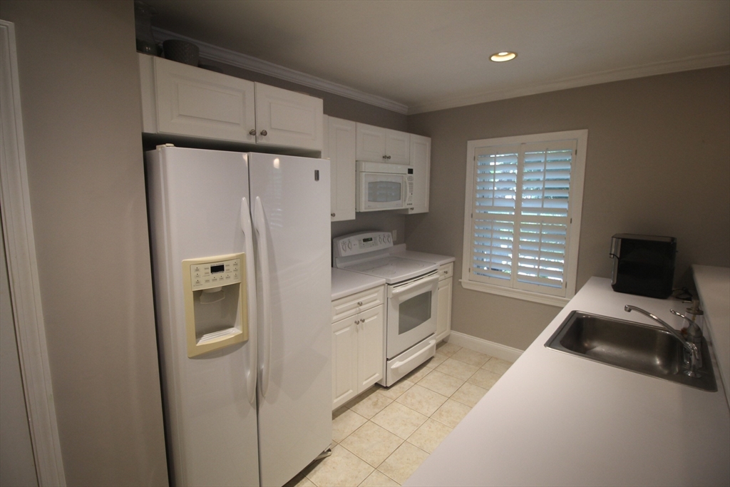 27 Commonwealth Avenue, Unit 1 Newton, MA 02467 - Photo 3 of 12 a kitchen with a refrigerator stove and a sink