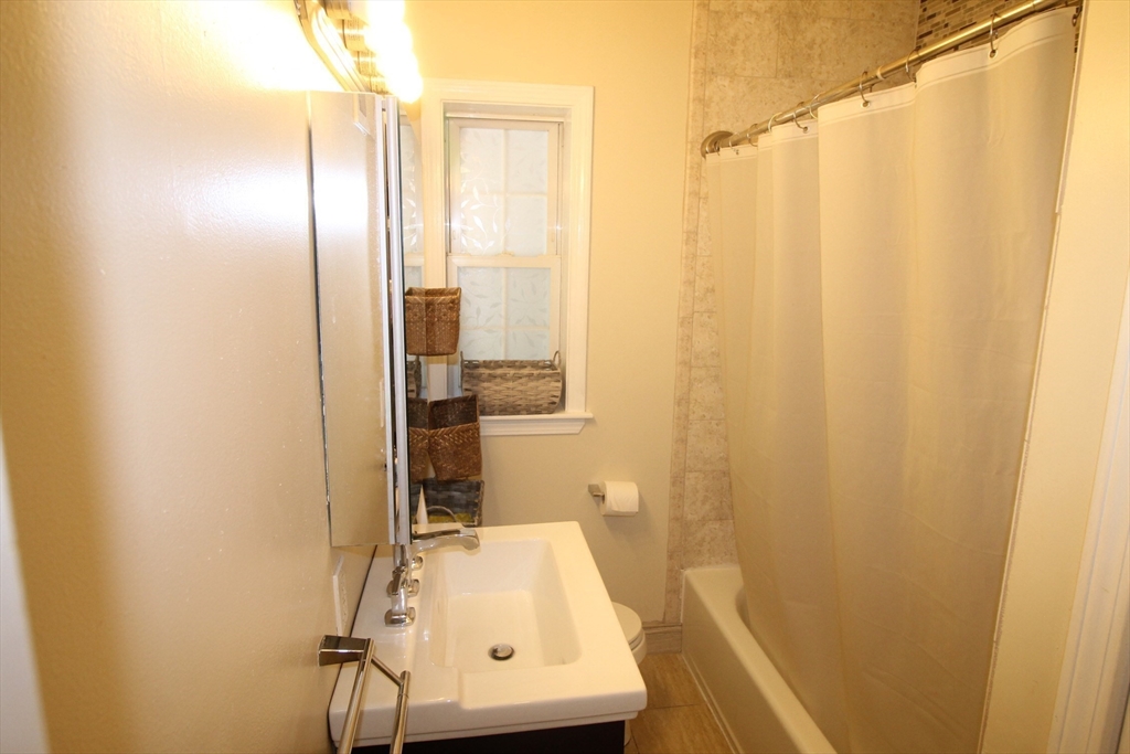 27 Commonwealth Avenue, Unit 1 Newton, MA 02467 - Photo 7 of 12 a bathroom with a sink and a mirror