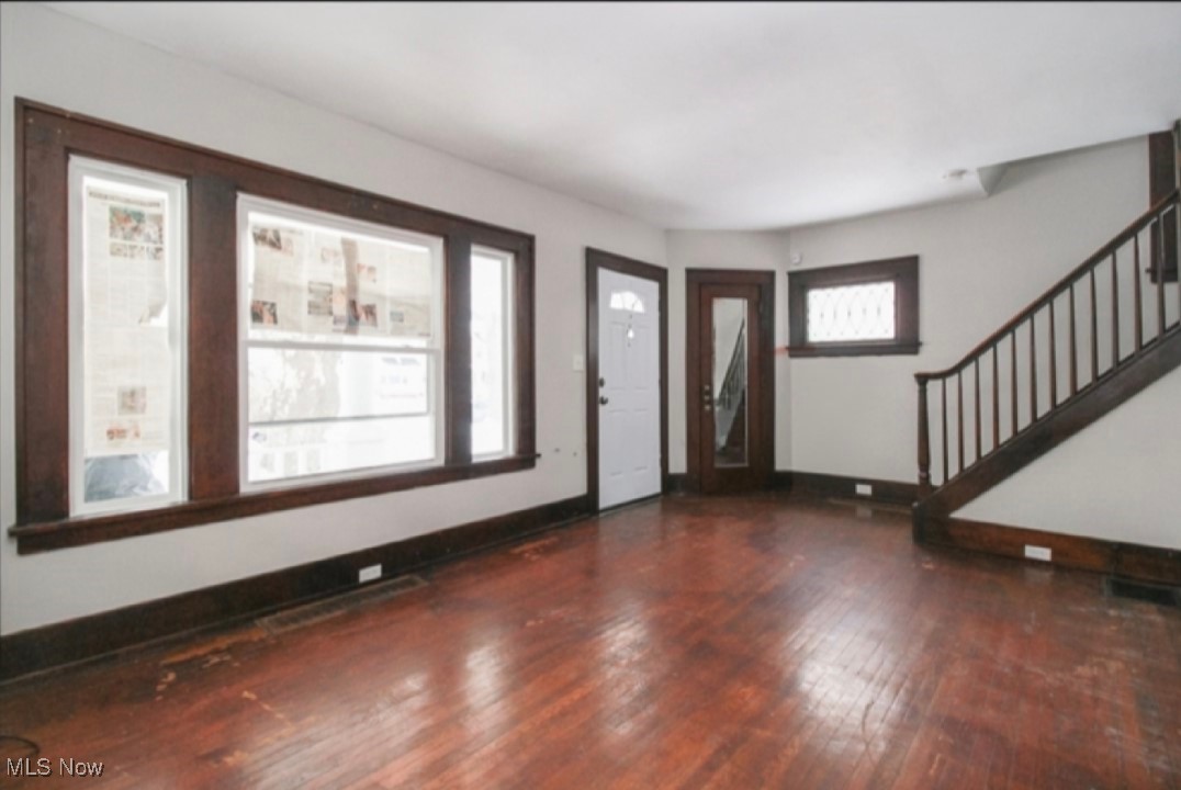 Entryway featuring baseboards, stairs, and hardwood / wood-style floors