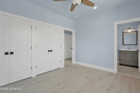 a bathroom with a toilet sink vanity granite and shower