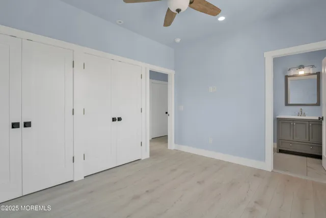 a bathroom with a toilet sink vanity granite and shower