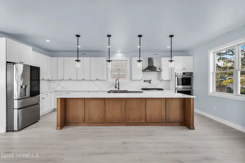 a kitchen that has a lot of cabinets and wooden floor